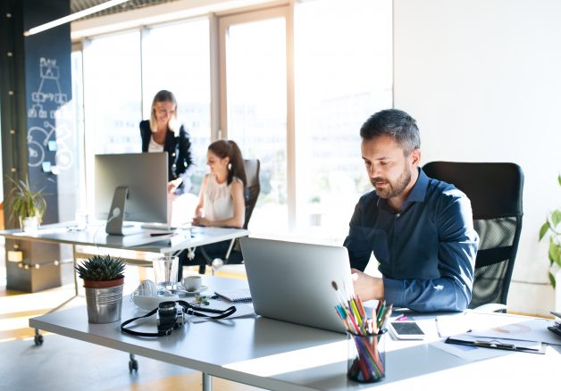 Three business people in the office working together.